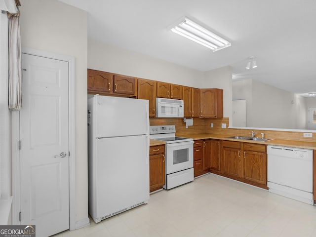 kitchen featuring sink, white appliances, and backsplash