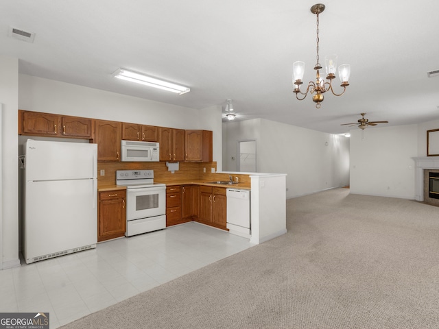 kitchen with sink, hanging light fixtures, ceiling fan, white appliances, and decorative backsplash