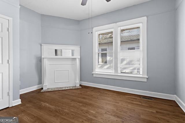 spare room with ceiling fan and dark hardwood / wood-style flooring