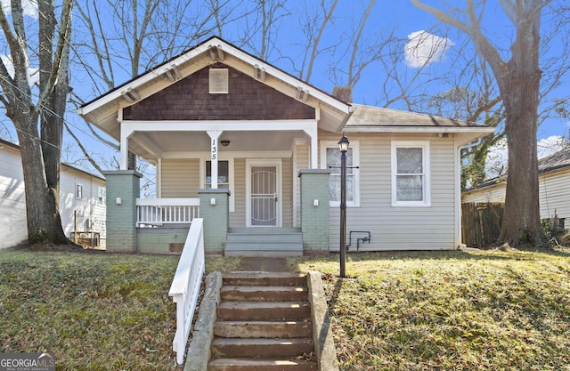 bungalow with a front yard and covered porch