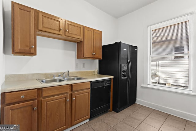 kitchen featuring sink, light tile patterned floors, and black appliances