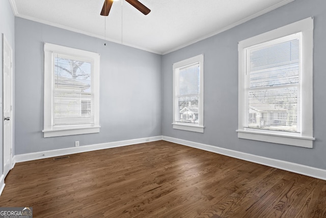 spare room with crown molding, dark wood-type flooring, and ceiling fan