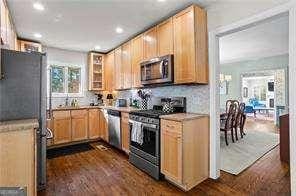 kitchen featuring appliances with stainless steel finishes, dark wood-type flooring, sink, and decorative backsplash