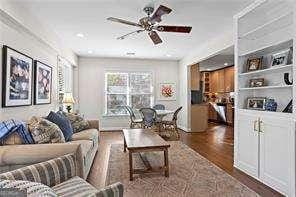 living room with ceiling fan and dark hardwood / wood-style flooring