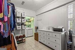 walk in closet with washing machine and clothes dryer and light tile patterned flooring