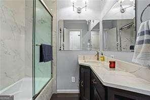 bathroom with vanity and bath / shower combo with glass door