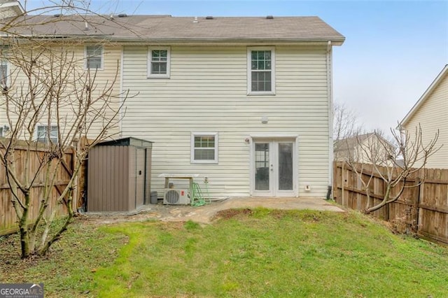 back of property featuring a storage unit, a yard, and french doors