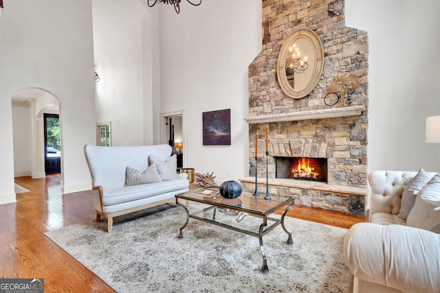 living room with hardwood / wood-style flooring, a fireplace, and a high ceiling