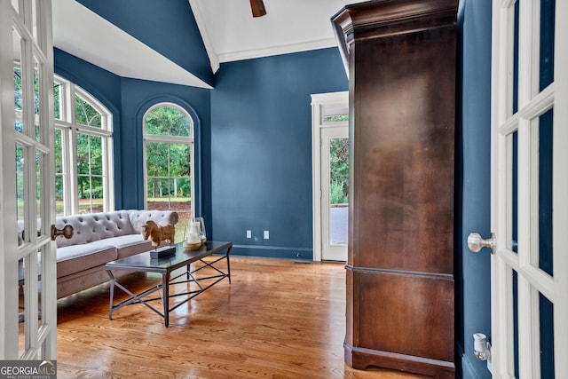 living room featuring ornamental molding, lofted ceiling, and light hardwood / wood-style floors