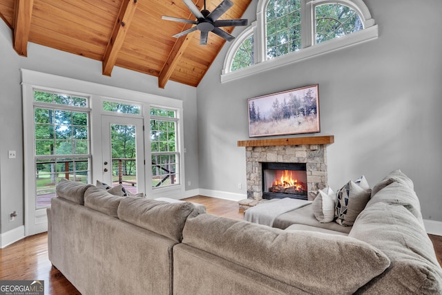 living room featuring wood ceiling, wood-type flooring, high vaulted ceiling, beamed ceiling, and a fireplace