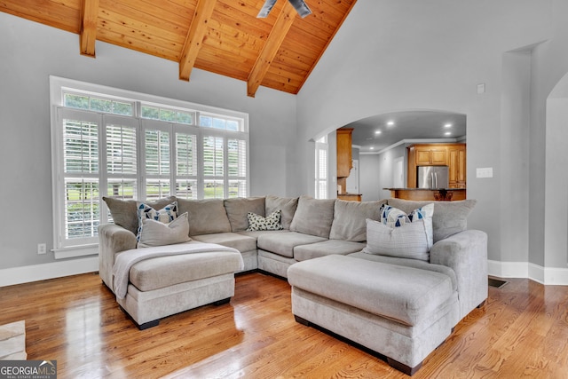 living room with beamed ceiling, plenty of natural light, light hardwood / wood-style flooring, and wooden ceiling