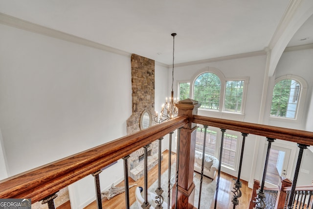 hall with crown molding, a notable chandelier, and light hardwood / wood-style flooring