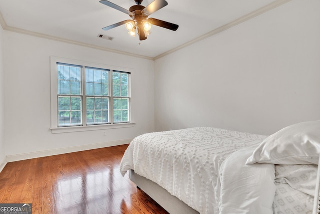 bedroom with hardwood / wood-style flooring, ceiling fan, and ornamental molding