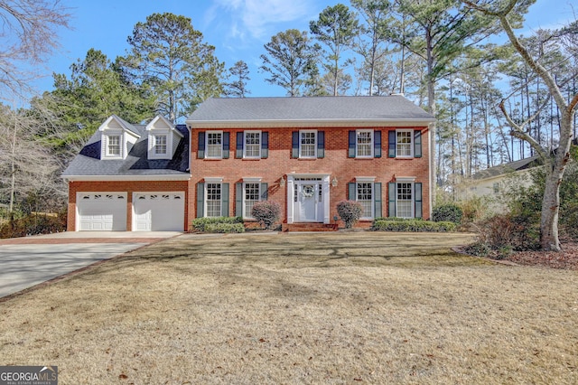 colonial house featuring a garage and a front yard