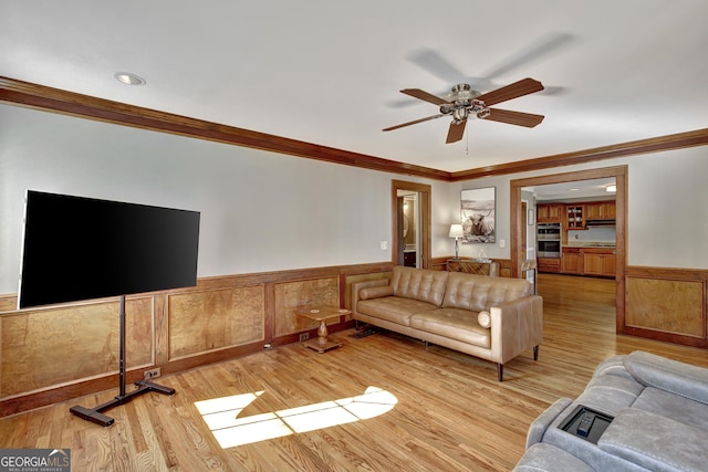 living room featuring crown molding, ceiling fan, and light hardwood / wood-style flooring