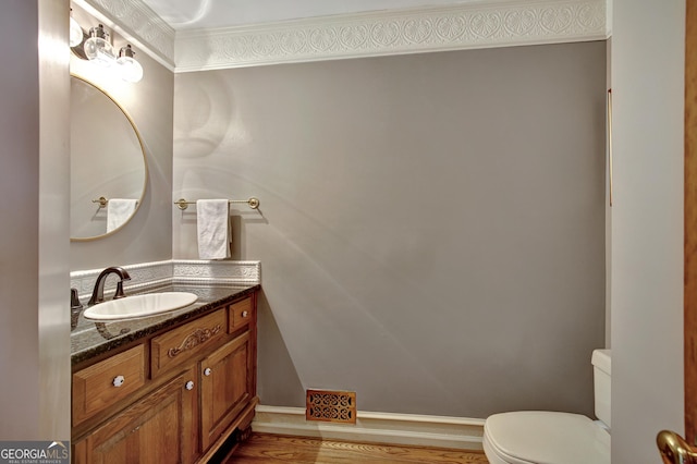 bathroom with hardwood / wood-style flooring, vanity, and toilet