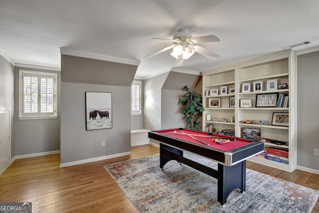 recreation room featuring crown molding, wood-type flooring, and a healthy amount of sunlight