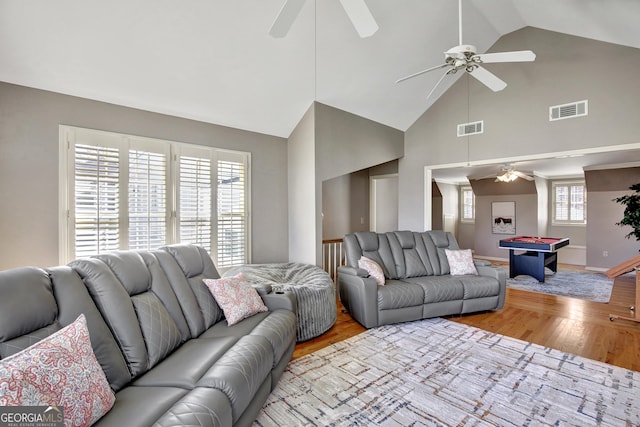 living room with ceiling fan, high vaulted ceiling, and light wood-type flooring