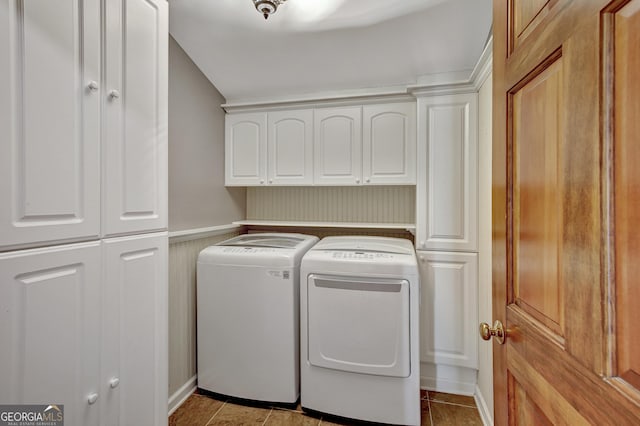 washroom featuring cabinets, light tile patterned floors, and washer and clothes dryer