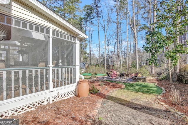 view of yard with a patio, a sunroom, and a fire pit