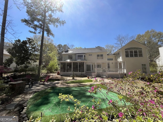 rear view of house with a sunroom and a patio