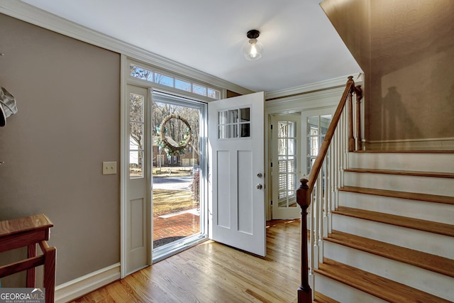 foyer featuring crown molding and light wood-type flooring