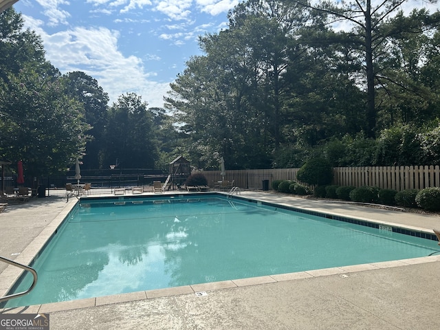 view of swimming pool featuring a playground and a patio area