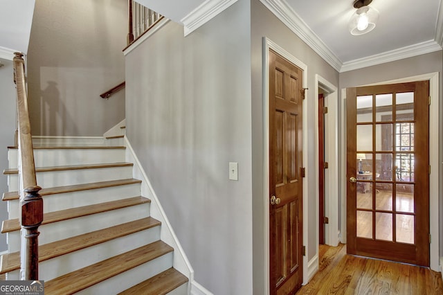 staircase with hardwood / wood-style flooring and crown molding