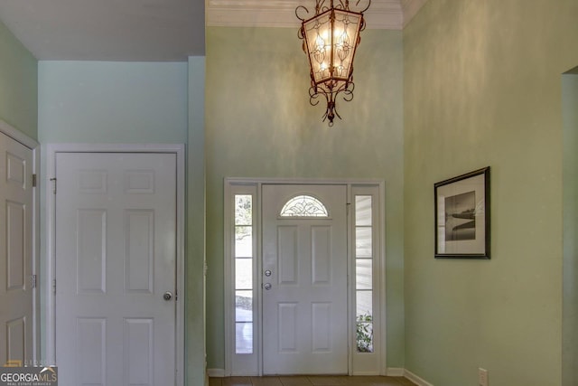 entrance foyer featuring an inviting chandelier and crown molding