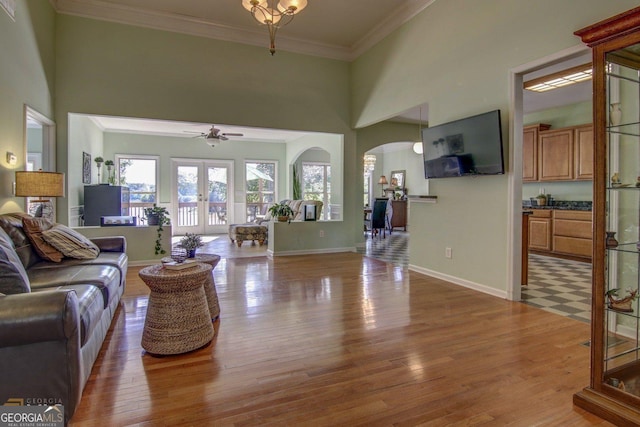 living room featuring hardwood / wood-style floors, crown molding, french doors, and ceiling fan