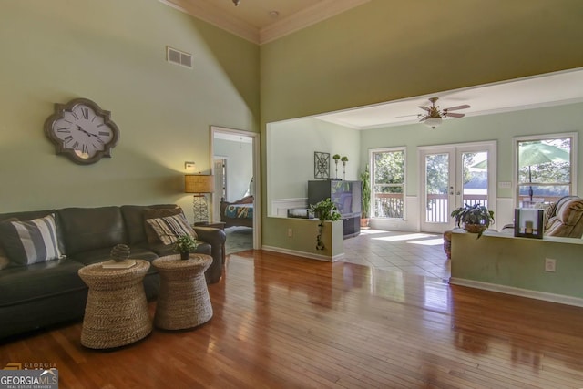 living room featuring crown molding, light hardwood / wood-style flooring, ceiling fan, and french doors