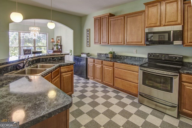 kitchen featuring pendant lighting, stainless steel appliances, an inviting chandelier, and sink