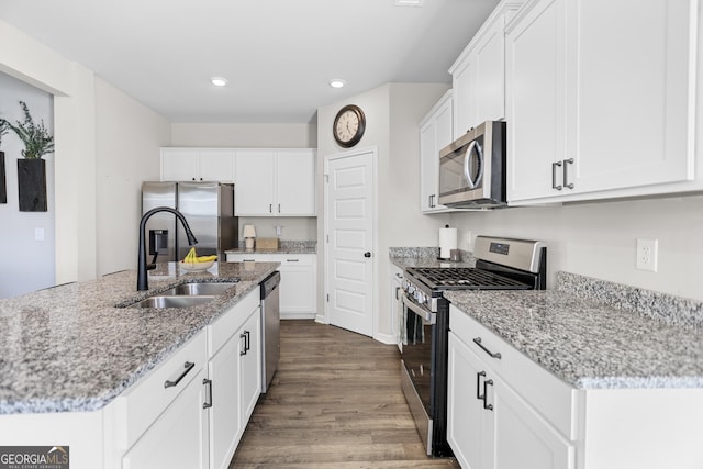 kitchen featuring white cabinetry, sink, light stone counters, and appliances with stainless steel finishes