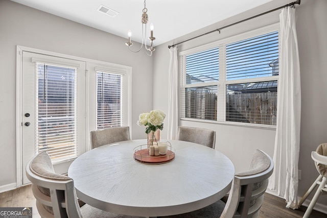 dining room featuring plenty of natural light, a chandelier, and dark hardwood / wood-style flooring