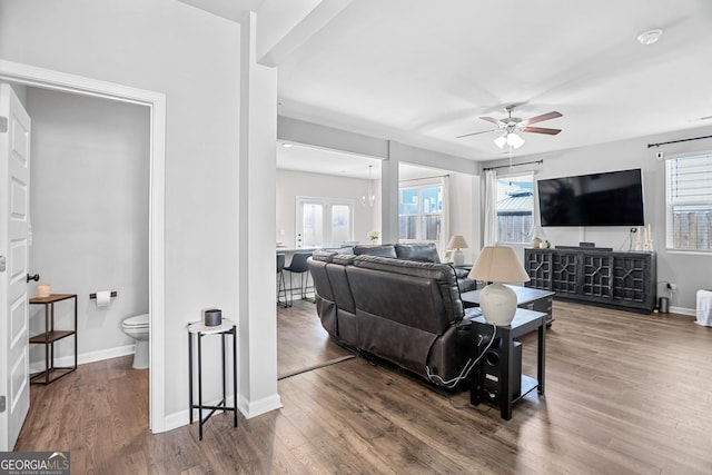 living room with hardwood / wood-style flooring and ceiling fan with notable chandelier