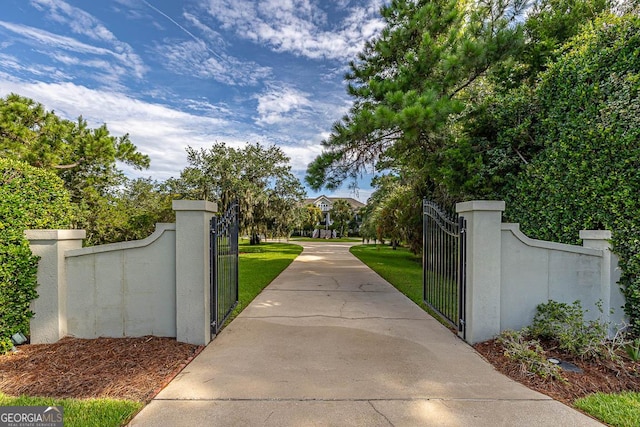 view of gate with a lawn