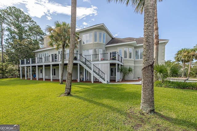 back of house with a wooden deck and a lawn