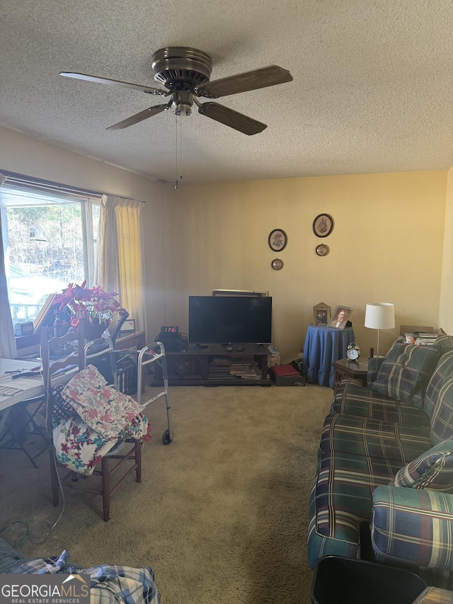 living room featuring ceiling fan, carpet flooring, and a textured ceiling