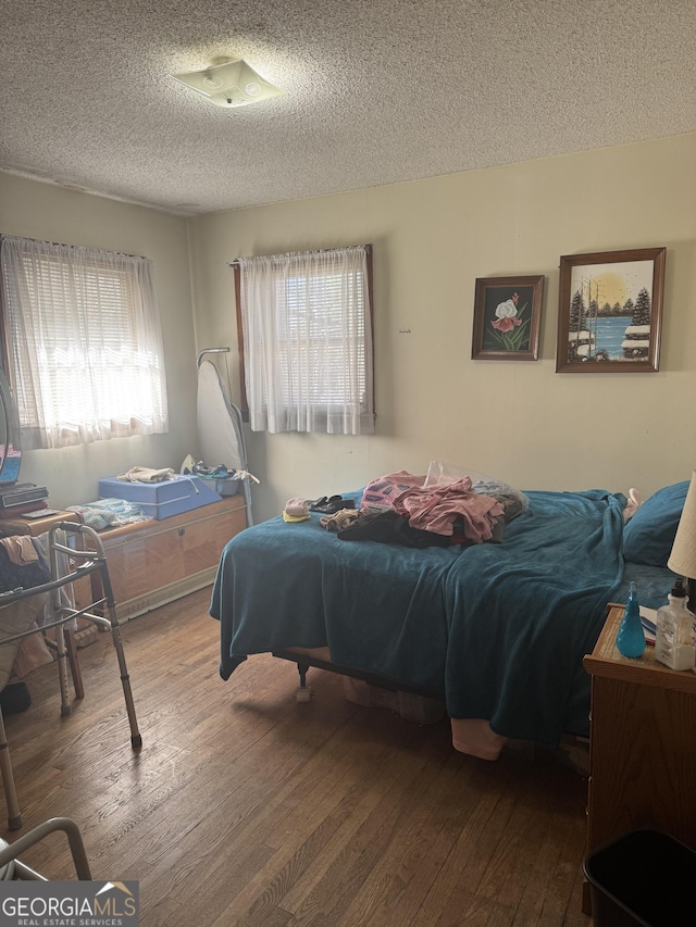 bedroom with hardwood / wood-style flooring and a textured ceiling