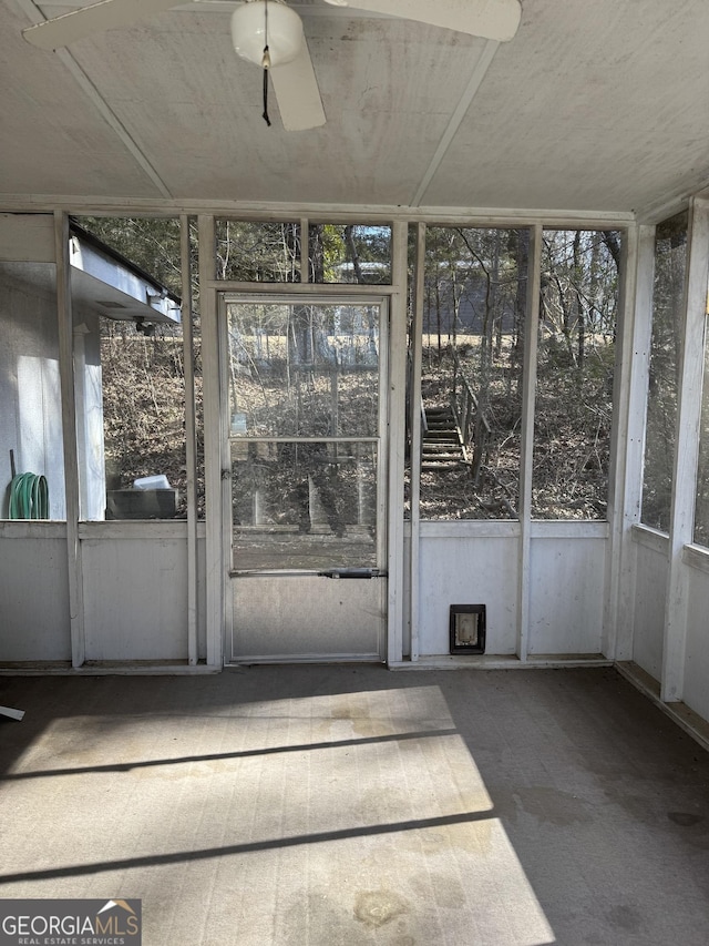 unfurnished sunroom with ceiling fan