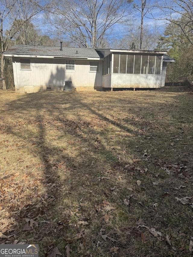 back of house featuring central AC, a lawn, and a sunroom