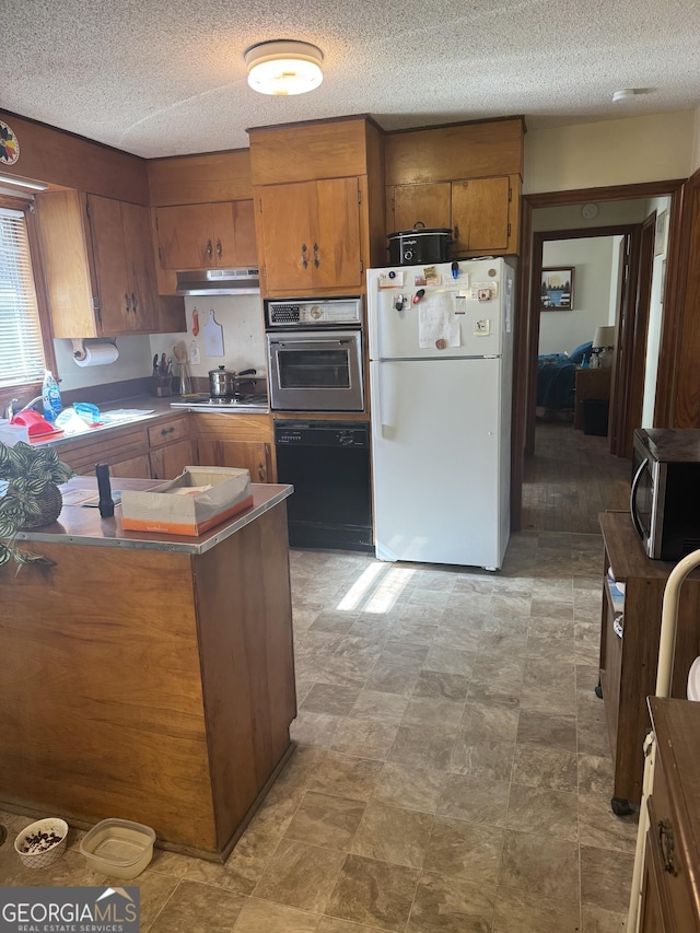 kitchen with a textured ceiling and appliances with stainless steel finishes