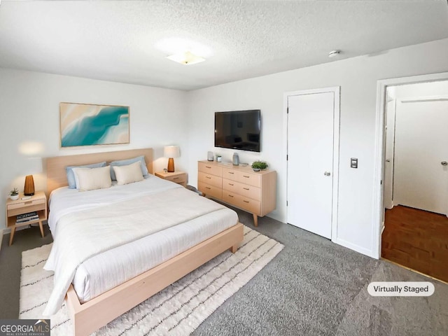 carpeted bedroom featuring a textured ceiling