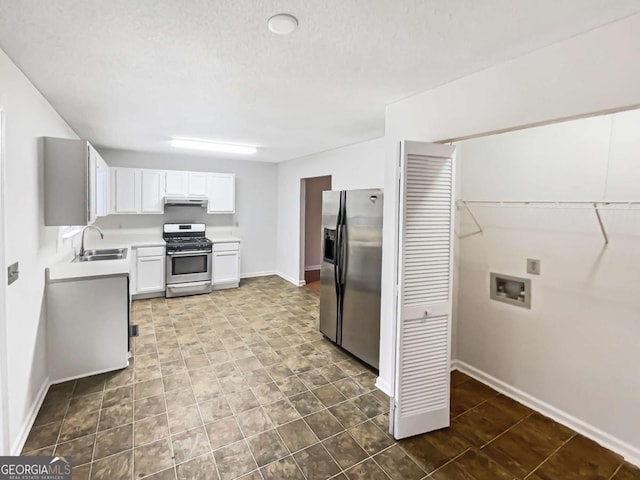 kitchen with white cabinetry, appliances with stainless steel finishes, sink, and a textured ceiling