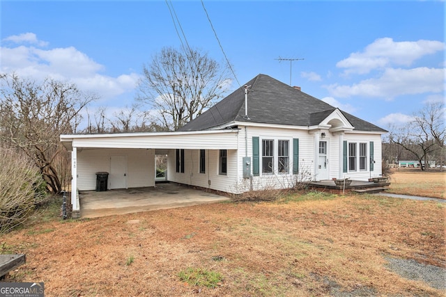 back of property featuring a lawn and a carport