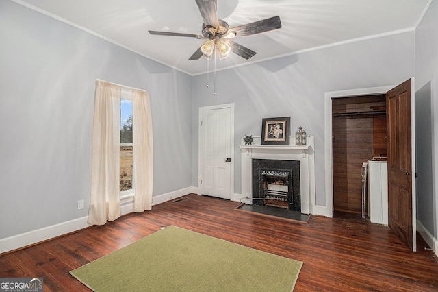 unfurnished living room featuring dark wood-type flooring, ceiling fan, and crown molding