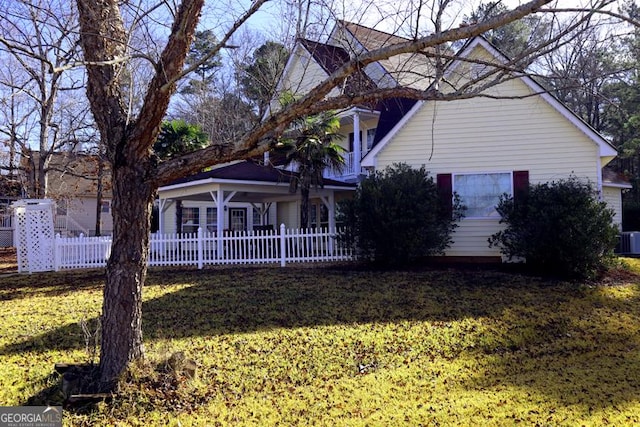 view of front of property with a front lawn and central air condition unit