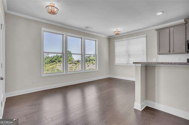 unfurnished dining area with ornamental molding and dark hardwood / wood-style flooring