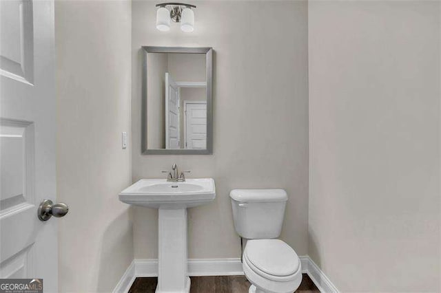 bathroom with sink, hardwood / wood-style flooring, and toilet