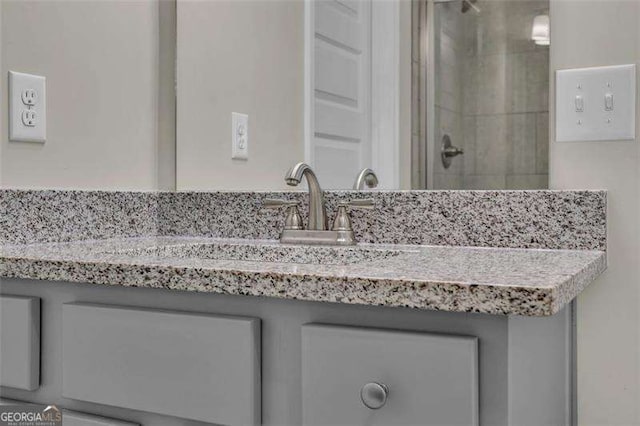 bathroom featuring a shower with door and vanity